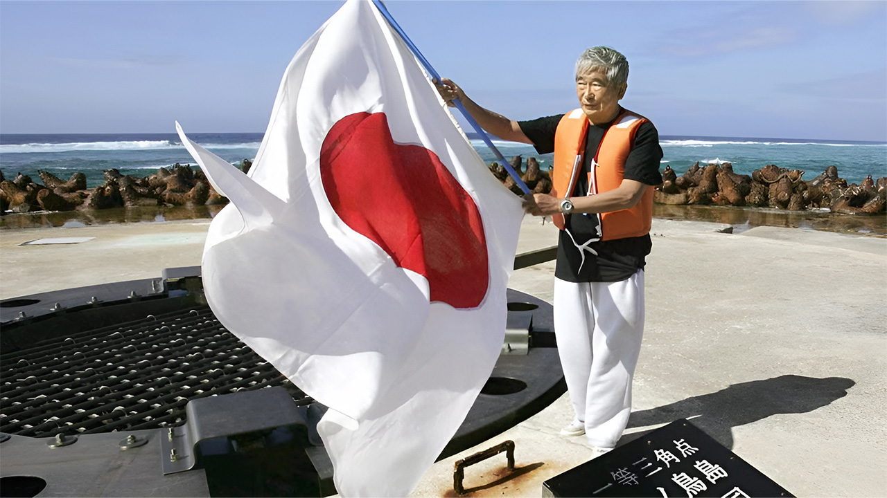 Okinotorishima adasında bayrak sallayan Japon