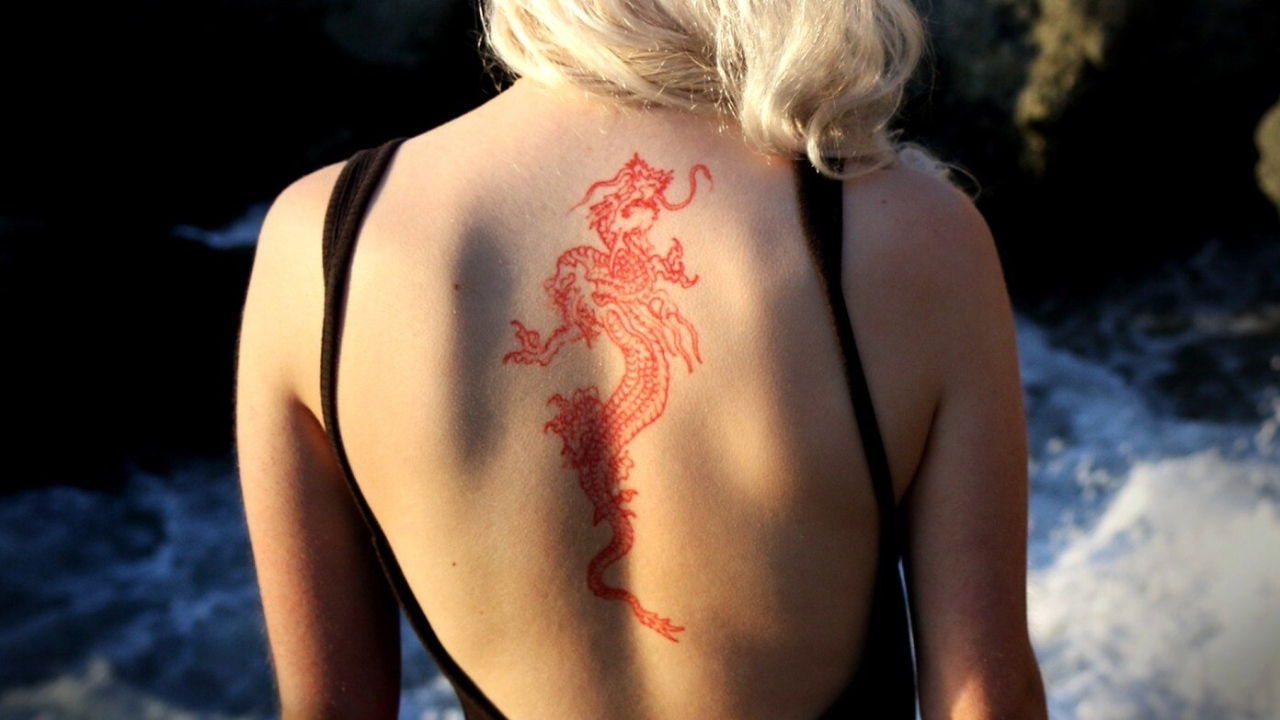 Woman with dragon tattoo on her back